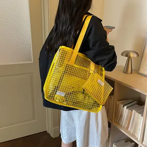 Yellow minimalist mesh tote bag with matching pouch worn by model in a stylish home setting