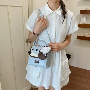 Detail of cute light blue cartoon dog shoulder bag with star patterns and bone tag