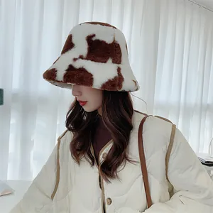 Side profile detail of a plush cow print bucket hat worn by a model in winter setting