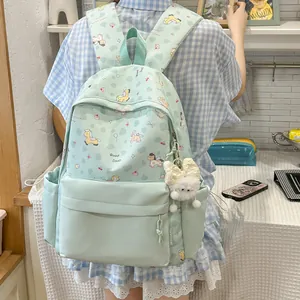 Detail view of mint green cartoon backpack with cute pony patterns and white plush charm