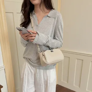 Détail d'un sac bandoulière beige de niche française pour un look quotidien minimaliste