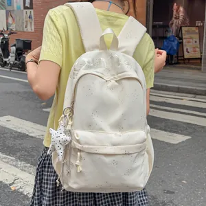 Trendiger cremeweißer Damenrucksack mit Sternenmuster, getragen von einem Modell