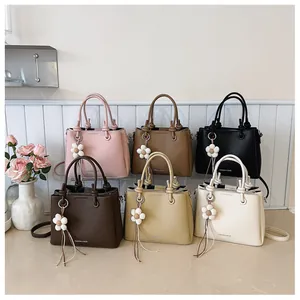 Bolsos de mujer elegantes en varios colores con dijes de flores decorativos y asas superiores