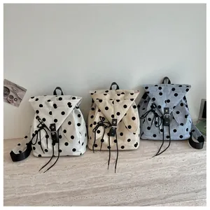 View of three casual polka dot backpacks in white beige and blue colors for summer