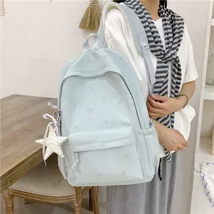 Stylish student carrying a fresh mint green floral backpack with a cute white star charm