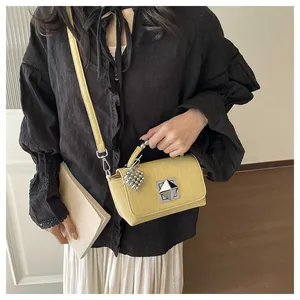 Fashionable yellow textured crossbody bag with silver heart charm and geometric clasp