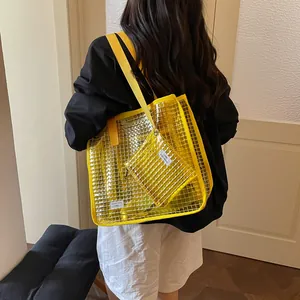 Rear view of a model carrying a large yellow transparent mesh tote bag with matching pouch