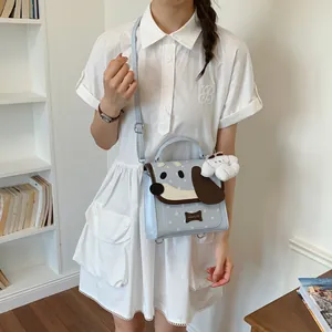 Close-up of cute light blue cartoon dog shoulder bag with star pattern and fluffy charm.