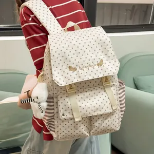 View of the star pattern women's backpack worn by a model with a plush bear keychain detail
