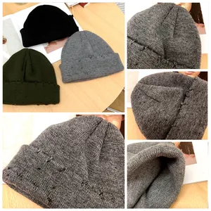 Gros plan détaillé montrant la texture du tricot et les bords usés d'un bonnet gris d'hiver.