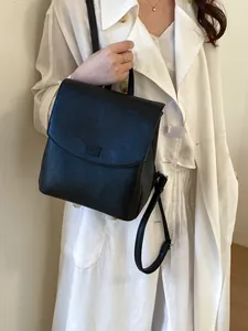 Elegant black faux leather backpack for women featuring a minimalist flap and handle design
