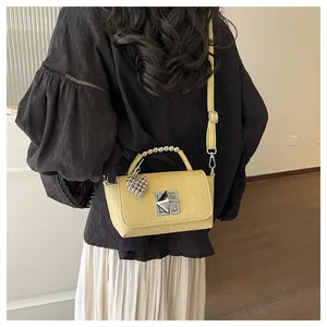 Stylish yellow small square crossbody bag with silver bead handle and heart charm.