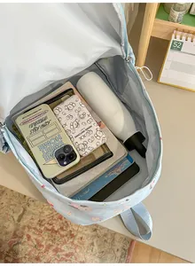 Spacious interior view of a cute light blue student backpack filled with school supplies.