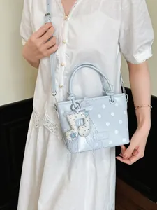 Stylish light blue polka dot crossbody handbag for women featuring a cute music note charm