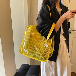Close-up view of stylish yellow transparent grid tote bag set worn by a female model