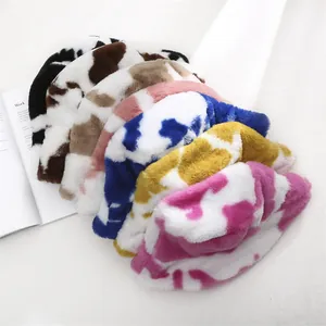 Collection of colorful plush cow print bucket hats in a stacked arrangement.