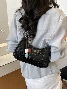 Elegant black crocodile pattern dumpling bag with colorful charms for women's fashion