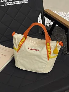 Fashionable cream grid tote bag with orange handles, perfect for yoga and fitness