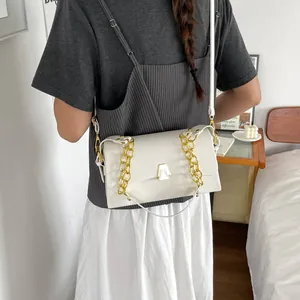 Elegant white crossbody square bag with gold chain strap shown on a stylish model