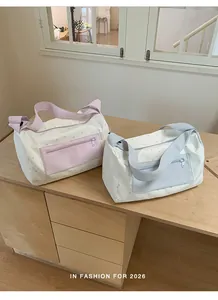 Detail view of pastel pink and light blue gym bags featuring star patterns on a wooden desk.