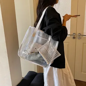 Detailed side view of a stylish transparent mesh grid tote bag carried by a model
