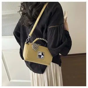 Detailed view of yellow fashion small square bag on model's back with beaded handle