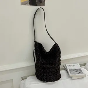 Dunkelbraune handgewebte Häkel-Beuteltasche in einer minimalistischen Lifestyle-Umgebung