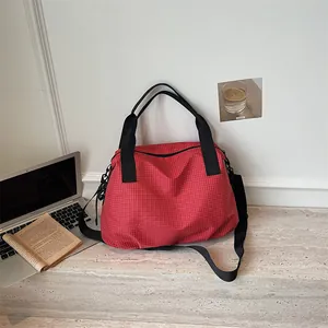 Primo piano della grande borsa da viaggio a scacchi rossi in un contesto di vita