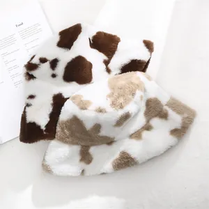Close-up of plush cow print bucket hats showing soft faux fur texture and warm winter style