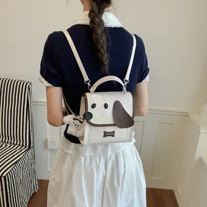 Rear view of a cute puppy-themed mini backpack in cream and brown with a plush dog charm