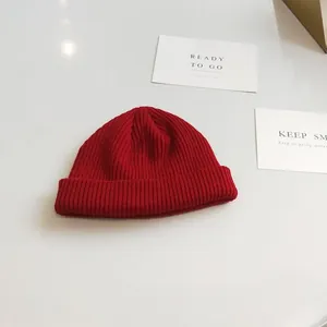 Vibrant red knit beanie hat featuring classic ribbed texture and a short cuff design