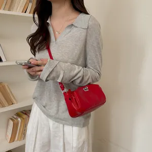 Sac à bandoulière rouge minimaliste français porté par un mannequin dans une bibliothèque