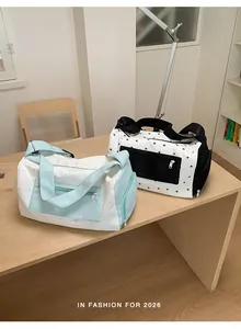 Detailed view of two star-patterned gym bags in mint green and black on a wooden table