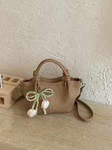 Vintage solid color bucket bag with a stylish green ribbon bow and pearl tulip charm