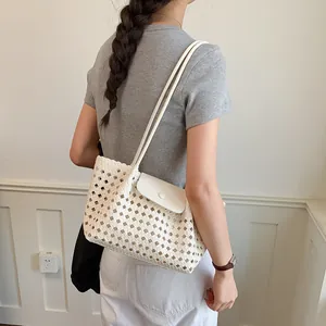 Elegante cremefarbene gewebte Tragetasche mit weißem Verschluss, ideal für den Sommerlook.