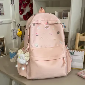 Detailed view of pink aesthetic school backpack with cute illustrations and plush charm