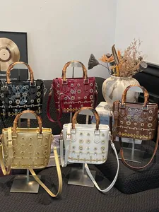 Premium patent leather shoulder bags with bamboo handles and floral rivet details