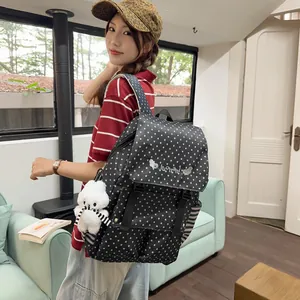 Stylish black backpack with white star patterns worn by a model in a cozy room environment.