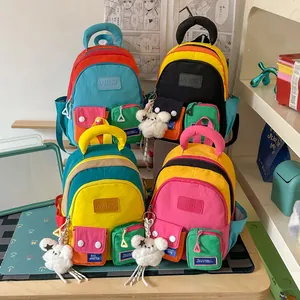 Detailed view of colorful multi-pocket school backpacks with plush bear keychains