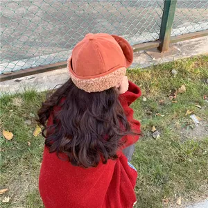 Rear view of woman wearing orange Japanese style warm plush landlord hat for winter