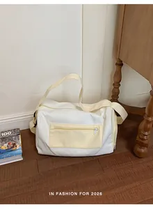 Minimalist white and cream duffel bag for gym or travel placed on a wooden floor.