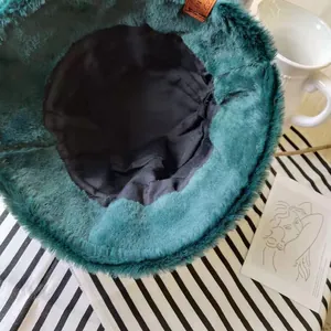Detailed view showing the black lining and soft faux fur of the emerald bucket hat