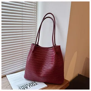 Detailed close-up of a vintage burgundy woven tote bag featuring large capacity style