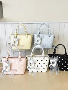 Trendy polka dot handbags available in five colors featuring cute musical note charms for women.