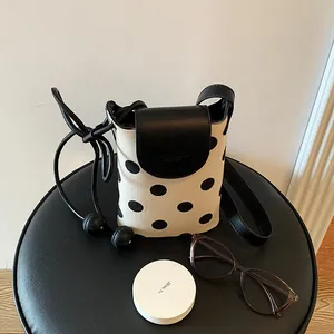 Elegant minimalist polka dot canvas crossbody phone bag for women with black leather flap detail