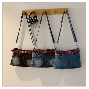 Three denim shoulder bags with unique skirt design and red belt details hanging on a rack.