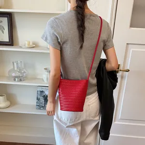 Detailansicht einer roten geflochtenen Eimertasche für ein lässiges Sommeroutfit
