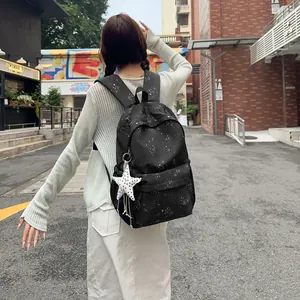 Schicker schwarzer Rucksack mit Sternenmuster, getragen von einem Model auf der Straße