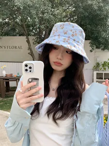 Femme portant un chapeau bob à fleurs bleu clair pour se protéger du soleil