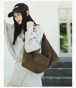 Detail view of an Asian model carrying a vintage large dark brown suede tote bag.